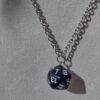 black, 20-sided die on a silver-coloured chain